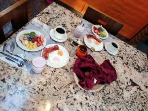 a table with plates of breakfast food on it at The Bridge to Ecuador in Quito