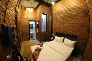 a bedroom with a large bed in a brick wall at Ban Loong Boutique Hotel in Ipoh