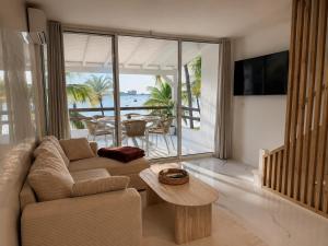 a living room with a couch and a table at Sunset Paradise in Baie Nettle