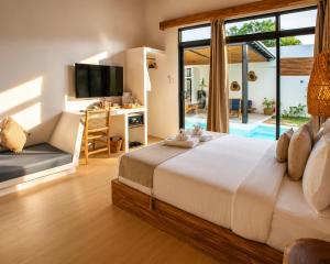 a bedroom with a large bed and a living room at Villa Kasadya in Panglao Island