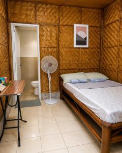 a bedroom with a bed and a desk and a fan at Backpackers & Event Lounge in Valencia