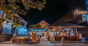 a restaurant with tables and benches in front of a building at Blue Marlin Dive Resort Trawangan in Gili Trawangan
