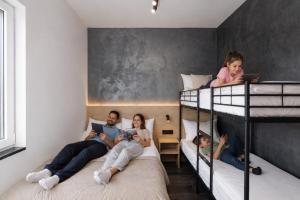 a group of people laying on bunk beds at Apartamenty Racławicka Mszczonów in Mszczonów +36 photos