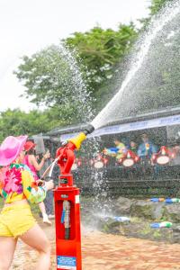 a girl is spraying water on a fire hydrant at Ecoland Hotel in Jeju