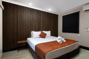 a hotel room with a bed and a flat screen tv at Beagle Hotel in Katherine