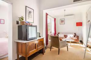 a living room with a tv on a wooden dresser at William Arnott Boutique Accommodation in Morpeth