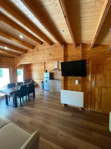 a living room with a table and a flat screen tv at Petit Chalet Cosy - Saint-Dié-des-Vosges T2 in Saint-Léonard