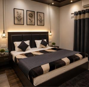 a bedroom with a large bed with black and white pillows at RadhaRaman StayInn in Mathura