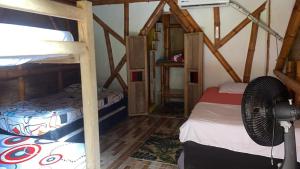 a room with two bunk beds and a fan at La aldea in Capurganá