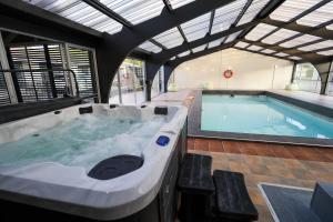 a large bath tub in a building with a pool at The Ashley Hotel Greymouth in Greymouth
