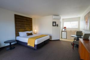 a hotel room with a bed and a desk at The Ashley Hotel Greymouth in Greymouth +55 photos