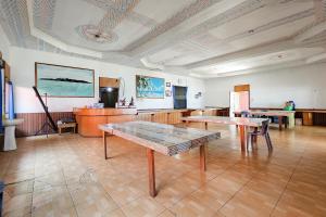 a large room with two tables and a kitchen at RedDoorz at Derawan Beach Cottage in Derawan Islands