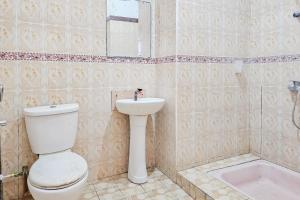 a bathroom with a toilet and a sink and a tub at RedDoorz at Derawan Beach Cottage in Derawan Islands +22 photos