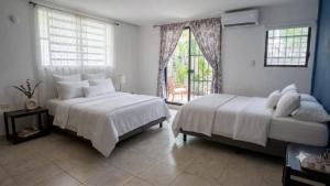 a bedroom with two beds and a window at Residencia COCO 28 con Piscina Downtown Cancun in Cancún +8 photos