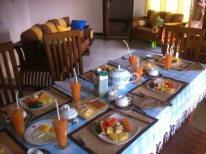 a table with plates of breakfast food on it at Bee Nest Bed & Breakfast in Negombo