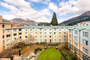 a building with a green lawn in front of it at Millennium Hotel Queenstown in Queenstown