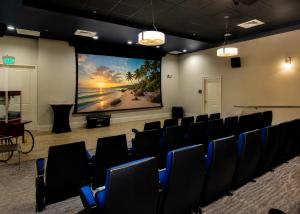 a room with chairs and a projection screen at Luxury Skyline Apartment- Resort-Style Pool , Gym & Game Room in Fort Myers +37 photos