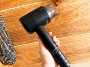 a hand holding a blow dryer on a wooden table at おきなわ民泊海族 in Okinawa City