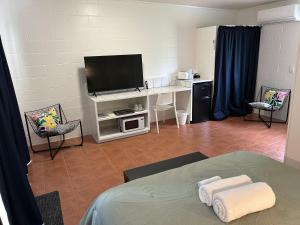 a room with a bed and a flat screen tv at Central Motel in Rarotonga