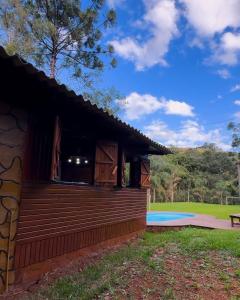 a cabin with a deck and a swimming pool at Ruhehaus in Arabutã