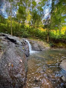 a small waterfall on the side of a river at Ruhehaus in Arabutã