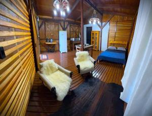 a bedroom with a bed and two chairs in a room at Ruhehaus in Arabutã