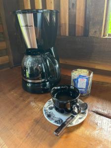 a blender and a cup of coffee on a table at Ruhehaus in Arabutã