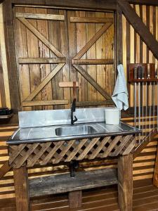 a sink in a room with a wooden wall at Ruhehaus in Arabutã +30 photos