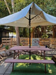 a picnic table with an umbrella on top of it at Roebuck Bay Backpackers in Broome +19 photos