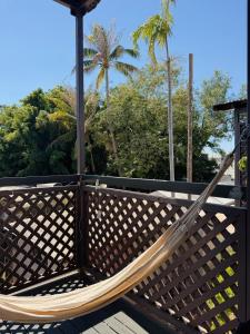 a hammock on a deck with trees in the background at Roebuck Bay Backpackers in Broome
