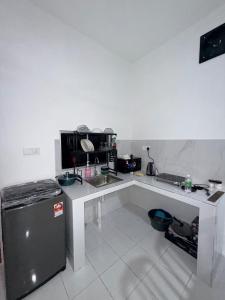 a small kitchen with a sink and a refrigerator at AiNi's Homestay 2 in Sipitang