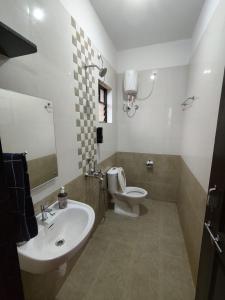 a bathroom with a white sink and a toilet at Casa Santana in Dabolim