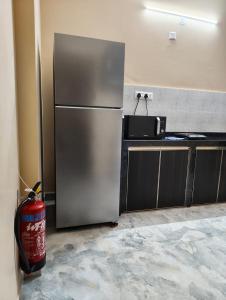 a kitchen with a refrigerator and a fire extinguisher at Casa Santana in Dabolim +13 photos