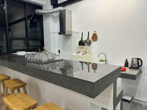 a kitchen with a counter with glasses on it at 9 mins to BTS Queen Private Room Share Bath in Amphoe Phra Khanong +17 photos