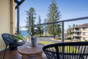 a table and chairs on a balcony with a view of the ocean at Seaspray Views - Lifestyle Yamba in Yamba