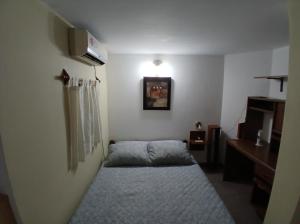 a small bedroom with a bed in a room at Neyen in La Plata