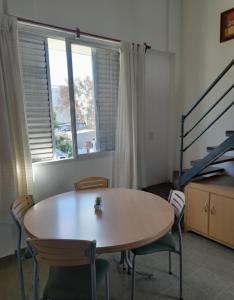 a table and chairs in a room with a window at Neyen in La Plata