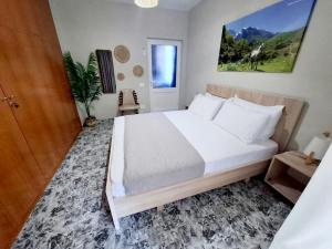 a bedroom with a large white bed in a room at Dhimarko Guest House in Përmet
