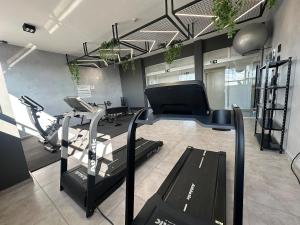 a gym with treadmills and machines in a room at Studio Brooklyn - 3 minutos da EPCAR in Barbacena