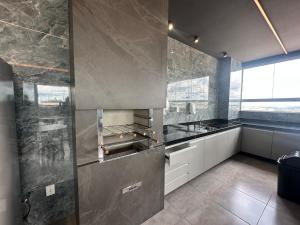 a kitchen with a sink and a counter top at Studio Brooklyn - 3 minutos da EPCAR in Barbacena