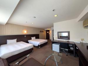 a hotel room with two beds and a desk at Green Rich Hotel Kagoshima Tenmonkan in Kagoshima +19 photos