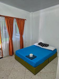 a blue bed in a room with curtains at Hotel Mar Azul in Acacías