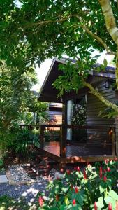 a cabin with a deck in a yard with flowers at Lush inn Phuket in Ban Suan