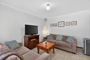 a living room with two couches and a flat screen tv at Cockles on Willmett road in Goolwa +13 photos