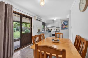 a kitchen and dining room with a wooden table and chairs at Cockles on Willmett road in Goolwa