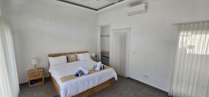 a white bedroom with a bed and a window at Villa Segara Agung Amed in Amed +26 photos