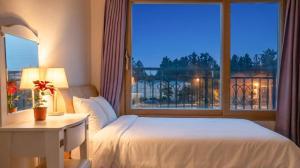 a bedroom with a bed and a window with a view at Jeju DK House Pension in Seogwipo