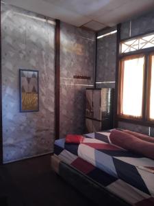 two beds in a room with a stone wall at STELAMARIS HomeStay in Pulau Bunaken