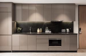 a kitchen with stainless steel cabinets and a stove at Walton Suites Sukhumvit in Bangkok