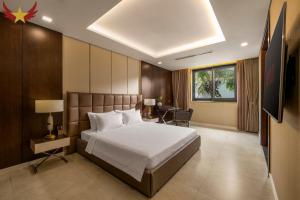 a hotel room with a bed and a desk and a window at The Five Stars Villa 6 Bedrooms Beachfront in Danang +87 photos